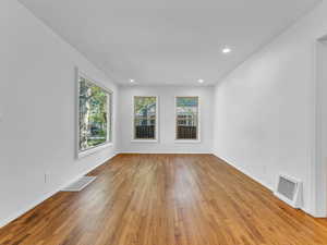 Spare room featuring hardwood / wood-style flooring, recessed lighting, and baseboards