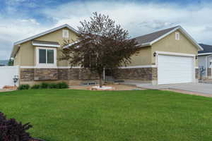 View of front of house with stone siding, stucco siding, and a front yard