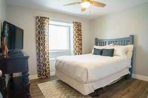Bedroom with wood finished floors, baseboards, and ceiling fan