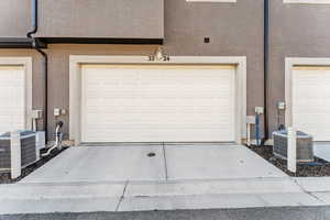 Garage featuring cooling unit and concrete driveway