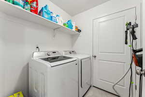 Laundry room featuring washer and dryer and light tile patterned floors
