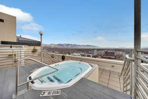 View of swimming pool with a mountain view and a hot tub
