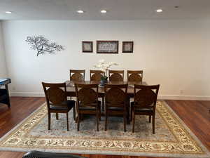 Dining space with wood finished floors, baseboards, a textured ceiling, and recessed lighting