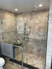 Full bath featuring a stall shower, toilet, and recessed lighting