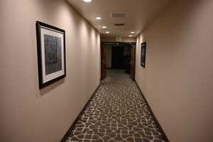 Corridor featuring recessed lighting, baseboards, and stone finish floors