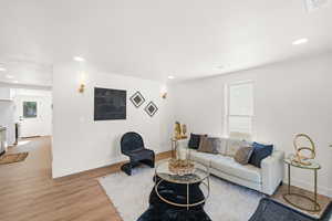 Living area with baseboards, light wood-style flooring, and recessed lighting