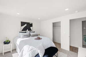 Bedroom featuring light colored carpet, recessed lighting, and a closet