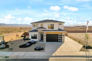 Modern home with an attached garage, concrete driveway, stucco siding, stone siding, and a mountain view