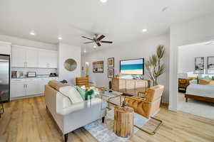 Living area featuring a ceiling fan, light wood-style flooring, and recessed lighting