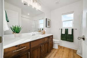 Bathroom featuring wood finished floors, toilet, vanity, and a shower with curtain
