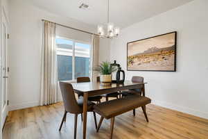 Dining area featuring a chandelier, light wood-type flooring, and baseboards
