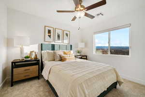 Bedroom with light colored carpet, baseboards, and a ceiling fan