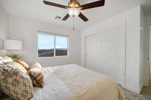 Carpeted bedroom with a closet, a ceiling fan, and baseboards