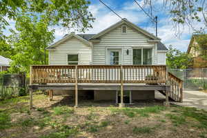 Back of property featuring a wooden deck and roof with shingles