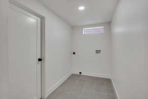 Laundry area with hookup for a washing machine, baseboards, electric dryer hookup, and tile patterned flooring
