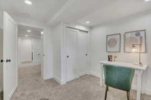 Hallway featuring light carpet, recessed lighting, and baseboards
