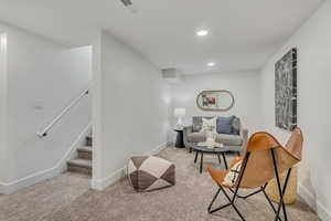 Living area with carpet, baseboards, stairway, and recessed lighting
