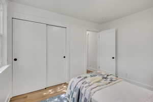 Bedroom with light wood finished floors and a closet