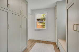 Mudroom featuring light wood-style flooring and baseboards