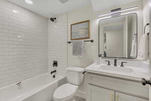 Full bath featuring toilet, vanity, and tub / shower combination