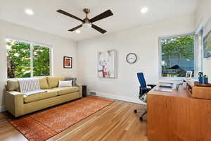 Home office with light wood finished floors, a ceiling fan, recessed lighting, and baseboards