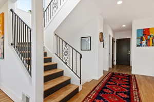 Foyer entrance with recessed lighting, wood finished floors, stairs, and baseboards