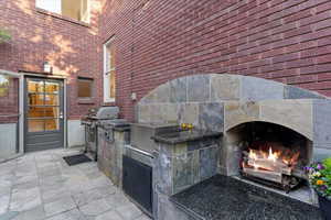 View of patio with a lit fireplace