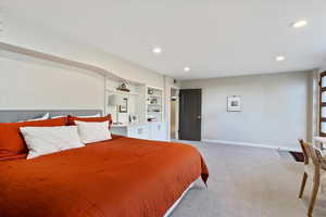 Bedroom with light carpet, recessed lighting, and baseboards