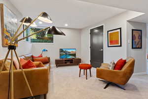 Carpeted living area featuring baseboards and recessed lighting