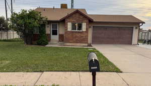 View of front of home with a garage, driveway, brick siding, and roof with shingles