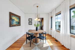 Dining area featuring light wood-style flooring, baseboards, and a chandelier