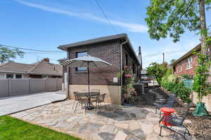 Back of house with brick siding, a patio area, and central AC unit