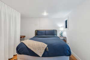 Bedroom featuring wood finished floors, baseboards, and recessed lighting