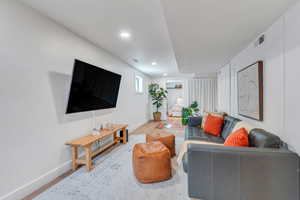 Living room with wood finished floors, baseboards, and recessed lighting