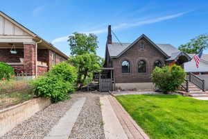 Tudor home featuring brick siding and a gate