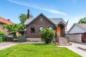 Tudor home featuring brick siding and roof with shingles
