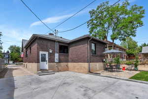 Rear view of house with brick siding, entry steps, and a patio