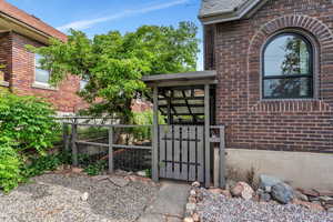Doorway to property with a gate and brick siding