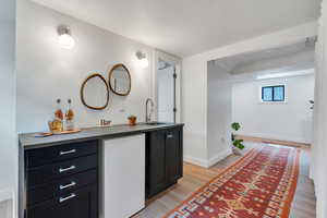 Bathroom featuring wood finished floors, vanity, baseboards, and a textured ceiling
