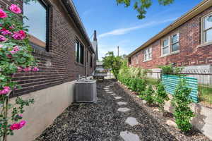 View of side of property with brick siding and central air condition unit