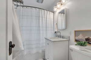 Full bath with toilet, vanity, and a shower with curtain