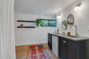 Full bath featuring vanity, wood finished floors, and baseboards