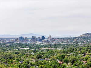 View of city featuring a mountain backdrop and a tree filled landscape
