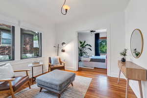 Living area with wood finished floors, baseboards, and ceiling fan