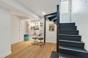 Stairs featuring wood finished floors and baseboards