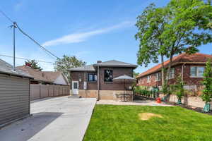 Rear view of property with brick siding, a patio, and a chimney