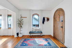 Entryway featuring plenty of natural light, light wood-style floors, and arched walkways