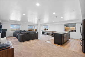 Living room with recessed lighting, baseboards, and light colored carpet