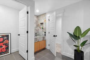 Bathroom with baseboards, a stall shower, tile patterned floors, recessed lighting, and vanity