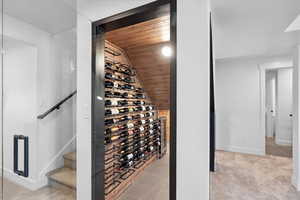 Wine area featuring wooden ceiling, baseboards, lofted ceiling, and carpet floors